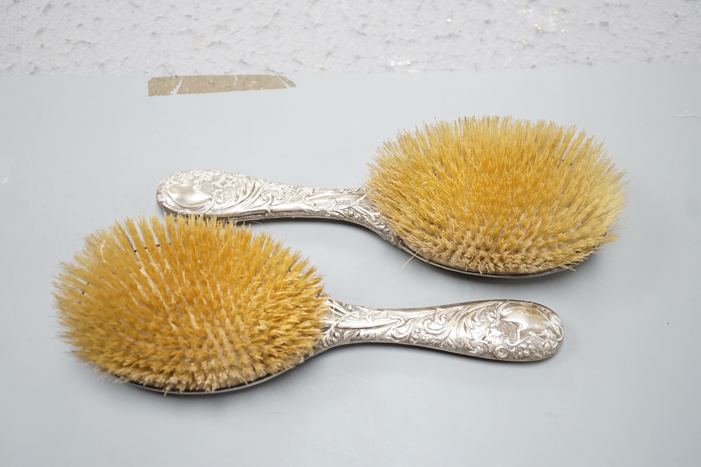 A pair of late Victorian repousse silver mounted hairbrushes, Birmingham, 1893.